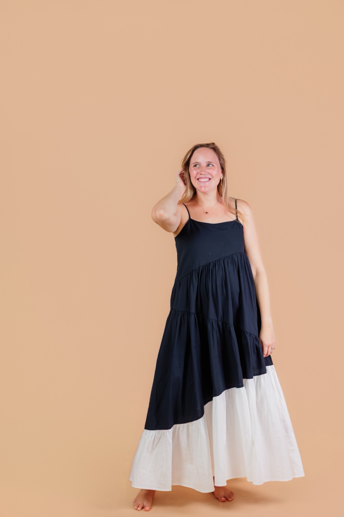 Lucia standing in a peach dress, smiling